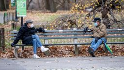 NEW YORK, NEW YORK - DECEMBER 02: Two men have a conversation while socially distancing and wearing masks in Central Park during the coronavirus (COVID-19) pandemic on December 02, 2020 in New York City. The pandemic has caused long-term repercussions throughout the tourism and entertainment industries, including temporary and permanent closures of historic and iconic venues, costing the city and businesses billions in revenue. (Photo by Roy Rochlin/Getty Images)