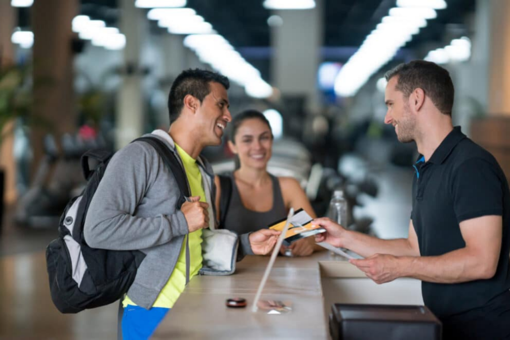 Man and woman checking in at gym desk